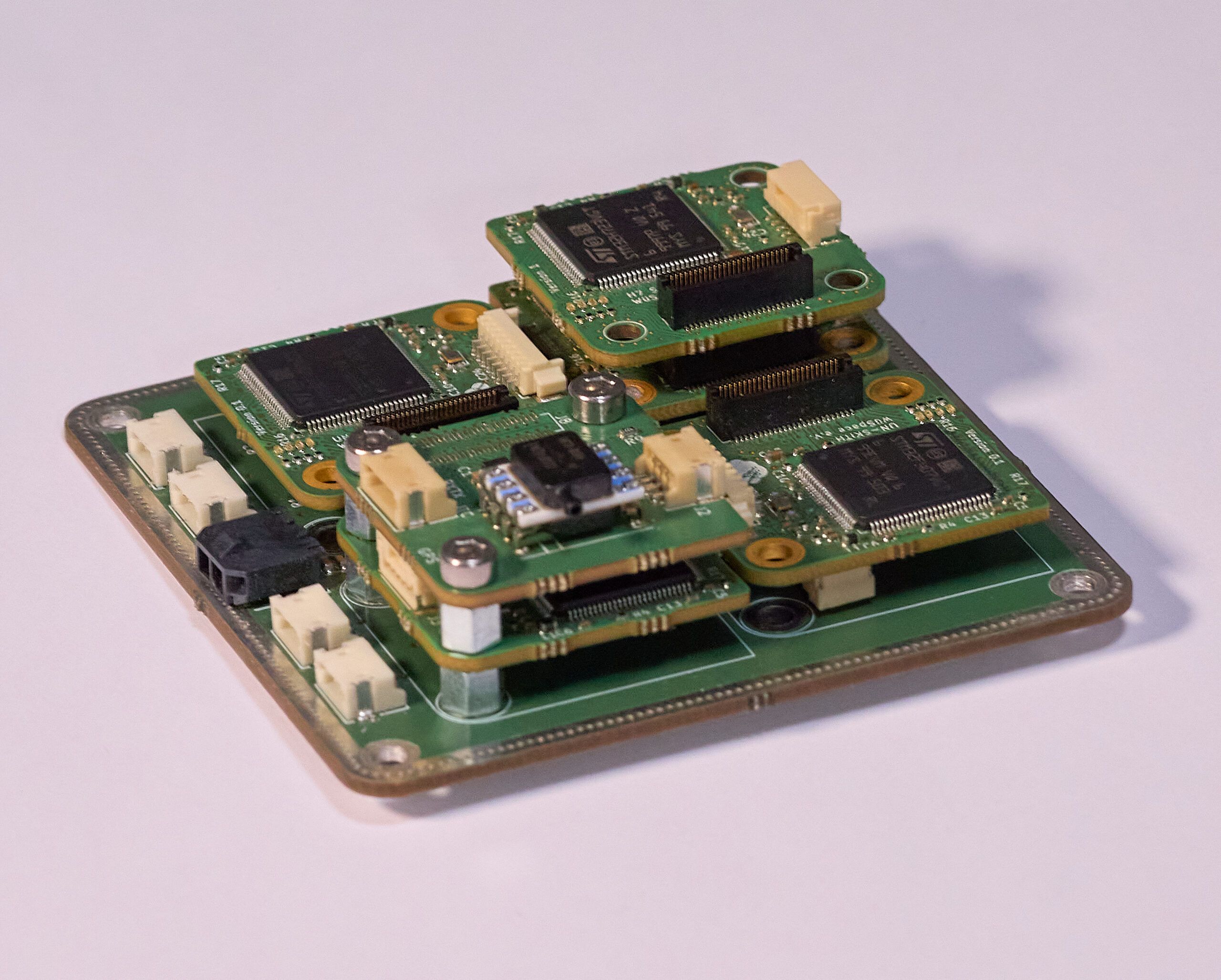 Close-up of the stacked redundant sensor boards, each carrying two IMUs, a magnetometer and a barometer